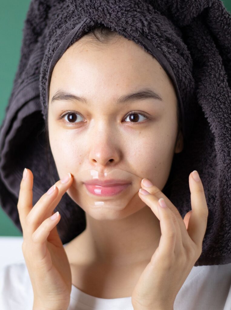 woman putting on lip mask