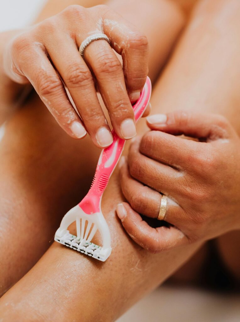 shaving legs with pink razor